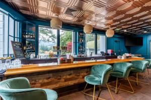un bar con sillas verdes en un restaurante en BW Premier Collection, Mt Hood Oregon Resort, en Welches