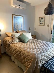 um quarto com uma cama com almofadas em Casa Feliz em San Fernando del Valle de Catamarca