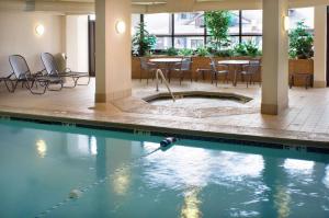- une piscine avec des chaises et des tables dans un bâtiment dans l'établissement Drury Inn & Suites Frankenmuth, à Frankenmuth