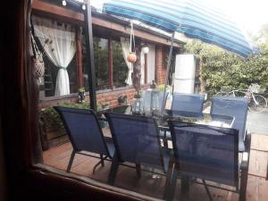 LO DE ROCCO في إيسكيل: طاولة مع كراسي ومظلة على الفناء