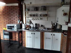 a kitchen with a microwave and a stove top oven at LO DE ROCCO in Esquel