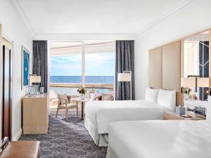 a hotel room with two beds and a view of the ocean at Fairmont Monte Carlo in Monte Carlo