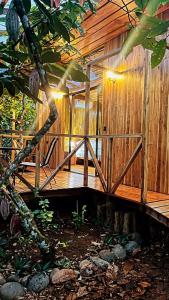 una casa de madera con una puerta de madera y un árbol en Cacahua Paradise Lodge, Río Celeste, en Rio Celeste