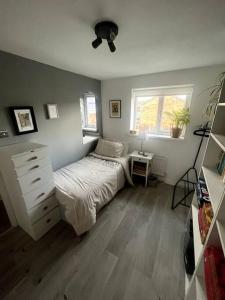 um quarto com uma cama, uma cómoda e uma janela em Detached House in Liverpool Suburbs em Woolton