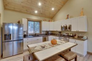 Una cocina con gabinetes blancos y un refrigerador de acero inoxidable. en Bigfork Cottage with Lake Views 5 Mi to Downtown, en Bigfork