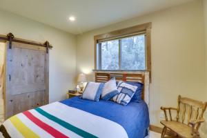 - une chambre avec un lit bleu et une fenêtre dans l'établissement Bigfork Cottage with Lake Views 5 Mi to Downtown, à Bigfork