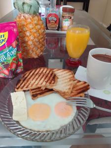 un plato de desayuno con huevos y tostadas y una taza de café en Casa turistica Miss G, en Providencia