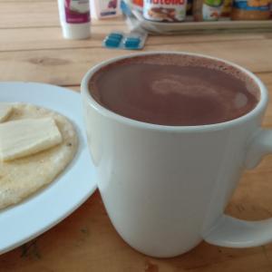una taza de chocolate caliente y un plato de mantequilla en Posada Nativa Miss G, en Providencia