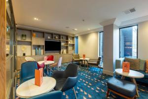 a hotel room with tables and chairs and a tv at Holiday Inn - Glasgow Airport by IHG in Paisley