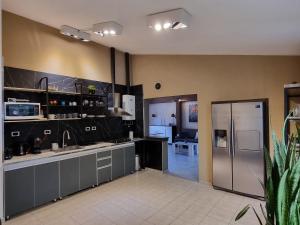 cocina con armarios grises y nevera de acero inoxidable en SLB Apart - Duplex en San Luis
