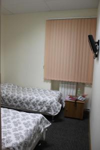 ein Krankenhauszimmer mit 2 Betten und einem Fenster in der Unterkunft Rinaldi at Petropavlovskaya in Sankt Petersburg