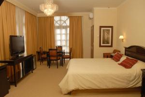 a hotel room with a bed and a television at Status Hotel in Río Grande