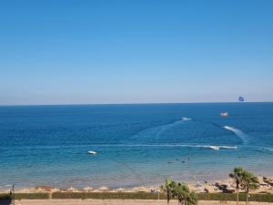 a beach with a group of people in the water at Porto sokhna Pyramids Apartments in Ain Sokhna