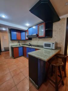 a kitchen with blue cabinets and a counter with a microwave at Porto sokhna Pyramids Apartments in Ain Sokhna