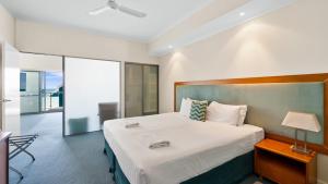 a bedroom with a large bed and a balcony at Sea Side 112 in Mandurah