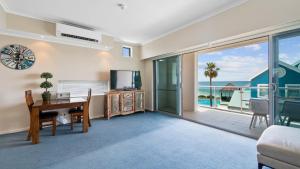 a living room with a desk and a view of the ocean at Sea Side 112 in Mandurah