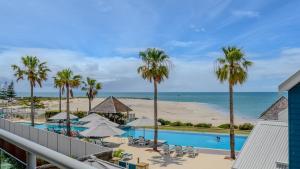 a view of the pool and beach from the balcony of a resort at Sea Side 112 in Mandurah