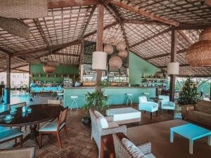 um restaurante com mesa e cadeiras e um bar em GP05 - Chalé em pousada a 300m da Praia do Amor em Pipa