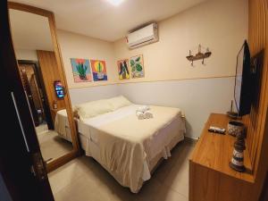 małą sypialnię z łóżkiem i lustrem w obiekcie GP05 - Chalé em pousada a 300m da Praia do Amor w mieście Pipa