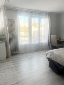 a bedroom with a bed and a large window at Le SerenityAppart Suresnes in Suresnes