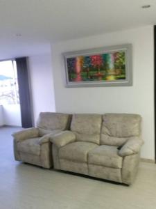 un sofá en una sala de estar con una pintura en la pared en Lujoso Hospedaje en las Alturas, en Tunja