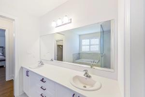a white bathroom with a sink and a mirror at Snow Valley Hideaway in Barrie