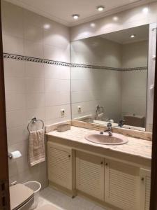 uma casa de banho com um lavatório e um espelho em Apartamento en Playa de Ondarreta em San Sebastián