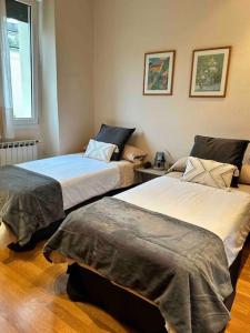 um quarto com duas camas e um sofá em Apartamento en Playa de Ondarreta em San Sebastián
