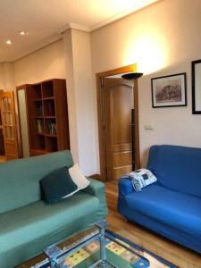 sala de estar con 2 sofás azules y mesa de cristal en Apartamento en Playa de Ondarreta, en San Sebastián