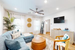 a living room with a blue couch and a tv at The Driftwood Sanctuary in Galveston