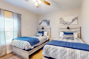 - une chambre avec 2 lits et une fenêtre dans l'établissement The Driftwood Sanctuary, à Galveston