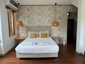 a bedroom with a large white bed with two tables at Blu Galapagos Sustainable Waterfront Lodge in Puerto Ayora +102 photos