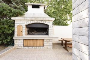 a brick oven with a wooden door in a patio at Apartment Sveti Petar 6158c in Sveti Petar