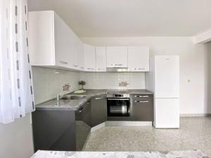 a kitchen with white cabinets and stainless steel appliances at Apartment Sveti Petar 6158c in Sveti Petar