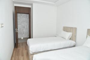 ein Zimmer mit 2 Betten und einem Sofa darin in der Unterkunft Lovely Apartment With Pool & Gym in Kenitra