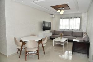 ein Wohnzimmer mit einem Sofa und einem Tisch in der Unterkunft Lovely Apartment With Pool & Gym in Kenitra