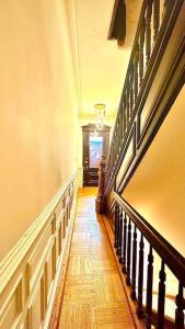 un pasillo de una casa con suelo de madera y escaleras en Airy, modern Penthouse in a Brooklyn Brownstone en Brooklyn