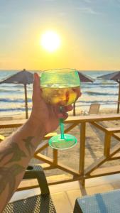 a person holding a drink in front of the beach at Suite privada frente al mar. in San Silvestre