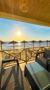 Suite privada frente al mar. في San Silvestre: شرفة مطلة على الشاطئ مع مظلات