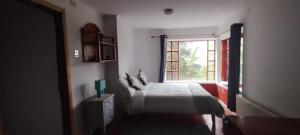 1 dormitorio con cama y ventana en Hostel Capanegra, en Castro