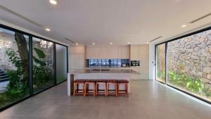 an open kitchen with a large island with stools at Promotion Early Booker Ocean Front Villa 500m2 with 4 bedrooms and swimming pool in Nha Trang