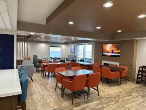 a restaurant with tables and chairs and a flat screen tv at Holiday Inn Express & Suites Eden Prairie - Minneapolis, an IHG Hotel in Eden Prairie