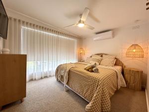a bedroom with a bed with a teddy bear on it at Boho Beach House in Rosebud