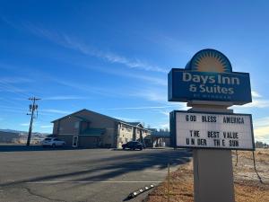 una señal para días posada y suites en una calle en Days Inn & Suites by Wyndham Gunnison en Gunnison