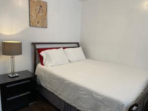 a small bedroom with a bed and a lamp at Beautiful private full condo in Brossard