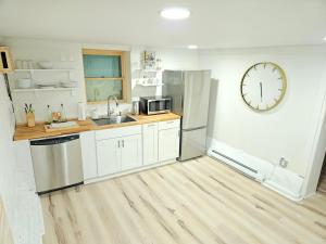 a kitchen with white cabinets and a clock on the wall at 2-Bedroom in the Heart of Denver in Denver