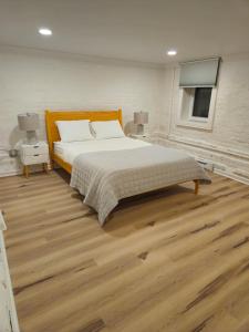 2-Bedroom in the Heart of Denver في دنفر: غرفة نوم بسرير كبير وأرضيات خشبية