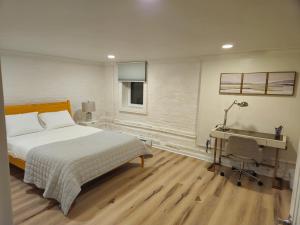 2-Bedroom in the Heart of Denver في دنفر: غرفة نوم بسرير ومكتب وجهاز كمبيوتر