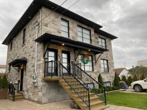 a brick house with a staircase in front of it at Beautiful private full condo in Brossard