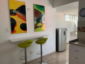 a kitchen with two green stools and a refrigerator at Apartamento Malí en Cali in Cali